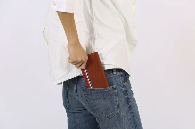 ジーンズの後ろポケットに財布を入れる男性